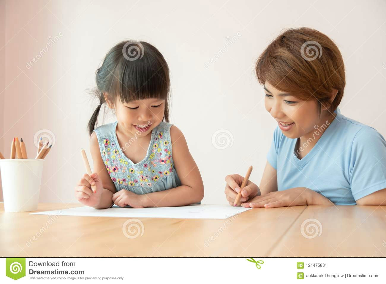 Drawing Of A Girl Sitting at A Desk Happy asian Mother and Daughter Drawing together Stock Image